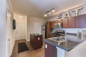 A kitchen with a sink, microwave, and oven.
